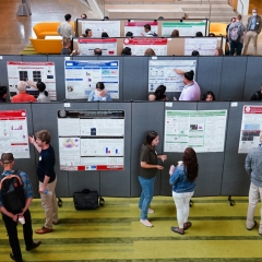 The image captures a poster session taking place in a large, modern building