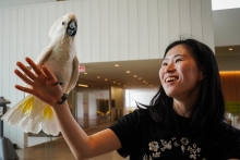 A student holding a cockatoo